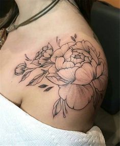 a woman's shoulder with flowers and leaves on the back of her body,