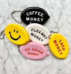 four key chains with smiley faces and words that say coffee money, flammy money, ice cream money, taco money