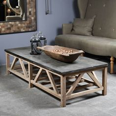 a table with a bowl on it in front of a couch and coffee table near by