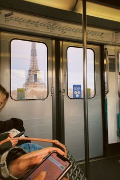 people sitting on a train looking out the windows at the eiffel tower in paris