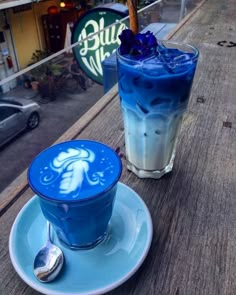 two drinks sitting on top of a blue plate next to each other in front of a building