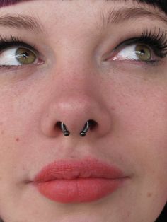 a woman with piercings on her nose looking at the camera