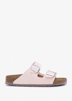 The popular ‘Arizona’ mules from Birkenstock have been given an update this Season. This classic staple Summer style is crafted from a premium vegan Birko-Flor upper with microfiber lining, cork foot-bed and EVA sole. An easy to wear slip on mule featuring two strap upper with buckle fastening. The foot-bed has been contoured to conform to the shape of your foot - with arch support and and extra layer of cushioning for optimum comfort. Signature Birkenstock branding is seen throughou Cute Shoes Sandals, Beachy Shoes, Summer Footwear Women, Pink Birkenstocks, Birkenstock Summer, Nb Shoes, Trendy Shoes Sneakers, Pretty Shoes Sneakers, Shoe Wishlist