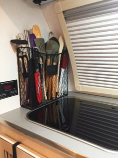 kitchen utensils are stored on the shelf above the stove