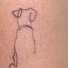 a dog tattoo on the back of a woman's left arm, with an outline of a dog