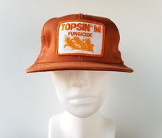 Original vintage 80's TOPSIN M FUNGICIDE mesh trucker hat in a unique carrot brown tone, with sewn in patch, and adjustable rear snapback strap.  Made in USA by I Hat Condition: Excellent (minor foam tear inside) see photo -  Lightly or never worn.   Size: Adjustable fitting for most adult head sizes up to a hat sizes 6 7/8 up to 7 5/8 Hat Patches, Snapback Cap, Ball Cap, Hat Sizes, Hat Making, Hats Vintage, Trucker Cap, Trucker Hat, Mesh