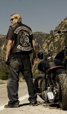 a man standing next to a parked motorcycle