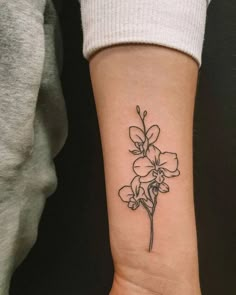 a small flower tattoo on the wrist