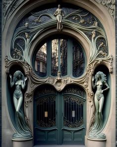 an ornate door with two statues on the front and one in the middle, at the entrance to a building