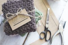 a pair of scissors sitting on top of a table next to some knitted items