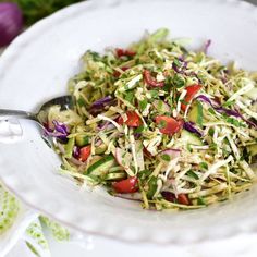 a salad in a white bowl with a spoon