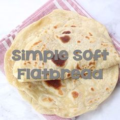 a stack of flatbreads sitting on top of a pink and white towel with the words simple soft flatbread