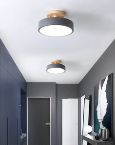 a hallway with grey walls and white flooring, two round lights above the door