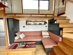 a living room filled with furniture and wooden stairs