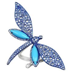 This dragonfly inspired ring is a delicate marvel crafted from white gold of platinum. Its wings, intricately detailed with filigree or engraving, showcase round-cut diamonds that sparkle with movement. A beautiful centrepiece is a captivating turquoise stone, adding a vivid touch of blue-green charm. This ring is a harmonious blend of nature-inspired design and luxurious gemstones, embodying elegance and timeless beauty. Gross weight: 14.96 g Diamond weight: 3.49 cts Dragonfly Ring, Green Charms, Beautiful Centerpieces, Nature Inspired Design, Turquoise Rings, Art Deco Diamond, Round Cut Diamond, Turquoise Stone, Timeless Beauty