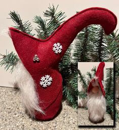 a red gnome's hat with snowflakes on it next to a christmas tree