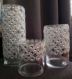 three glass vases sitting on top of a table