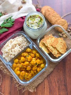 three plastic containers filled with food sitting on top of a wooden table next to bread