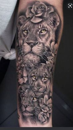 a black and white tattoo with lions, roses and leaves on the arm is shown