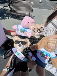 two women sitting on a bench with teddy bears wearing t - shirts that say yes to the world