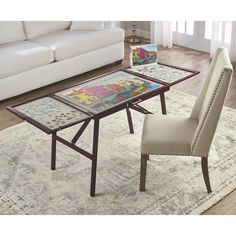 a living room with a couch, table and chair in it on top of a rug