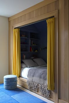 a bedroom with blue carpet and yellow curtains on the window sill in front of it