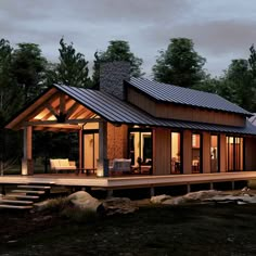 a small cabin style house with a porch and covered patio in front of it at night