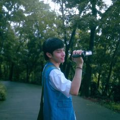 a young man is drinking from a water bottle