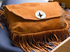 a brown purse sitting on top of a blue chair