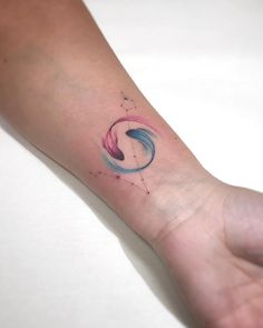 a person's hand with a small tattoo on the wrist and an abstract design