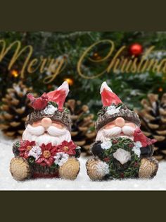 two santa claus figurines sitting next to each other in front of a christmas tree