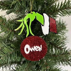 an ornament hanging from a christmas tree with the word owen painted on it