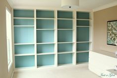 an empty room with blue bookcases in it