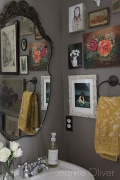 a bathroom with pictures and flowers on the wall