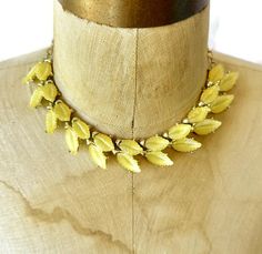 Take a step back in time to the 50s! This is a vintage plastic thermoset lucite plastic necklace. It is done in a beautiful warm gold and soft yellow shades. It has a double row of lucite leaves!  This is done in a gold tone metal. It has a hook closure so that it is adjustable in length. Very retro, classy chic! How fun! Condition: Very good vintage condition, vintage patina consistent with age - this is in amazing, clean condition!  Measurements:  14" - 17" long Weight: 39.3 grams I am not an expert on vintage jewelry, but I do buy and sell what I love! Since these items are vintage, they may have a wonderful aged patina and are not meant or expected to look brand new. I treasure their imperfections as part of their charm and history. More Vintage Plastic Jewelry: https://www.etsy.com/sh Plastic Necklace, 50s Vintage, Soft Yellow, Plastic Jewelry, Wedding Jewellery Necklace, Classy Chic, Shades Of Yellow, Vintage 60s, Wedding Necklace