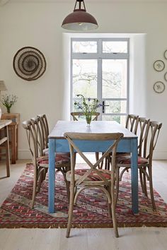 a dining room table with chairs and a rug