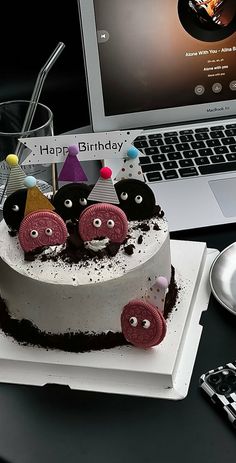 a birthday cake sitting in front of a laptop computer