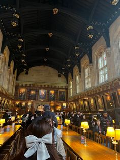 people are sitting at tables in a large room with paintings on the walls and ceiling