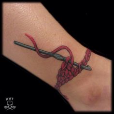 a tattoo on the foot of a person with a red ribbon and two crossed swords