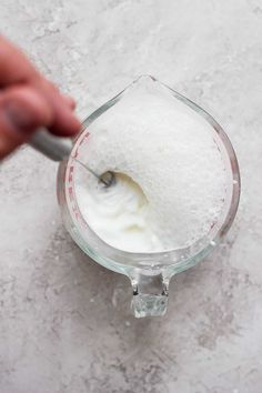 someone is using a spoon to mix the ingredients in a blender for making ice cream