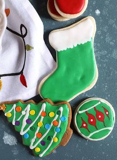 decorated christmas cookies and cookie cutters on a table