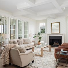 a living room filled with furniture and a fire place in the middle of a room