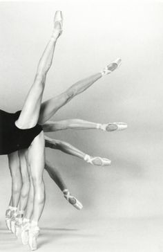 a black and white photo of a ballerina doing a handstand with her legs stretched out