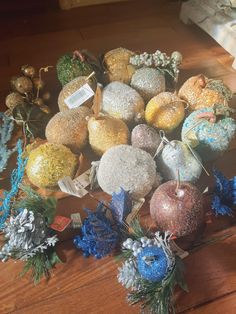 a pile of christmas ornaments sitting on top of a wooden table next to other decorations