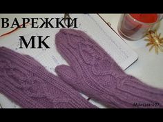 two purple knitted mittens sitting on top of a table