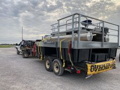 a large truck is parked in a parking lot with other trucks and equipment behind it