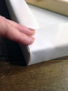 a person's hand on top of a piece of white paper