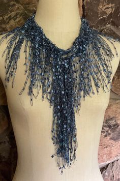 a mannequin wearing a blue beaded necklace