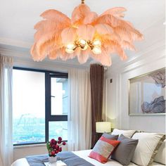 a bed room with a neatly made bed and a chandelier hanging from the ceiling