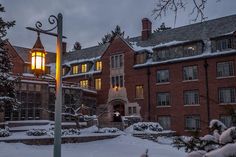 a street light in front of a large brick building covered in snow at night time